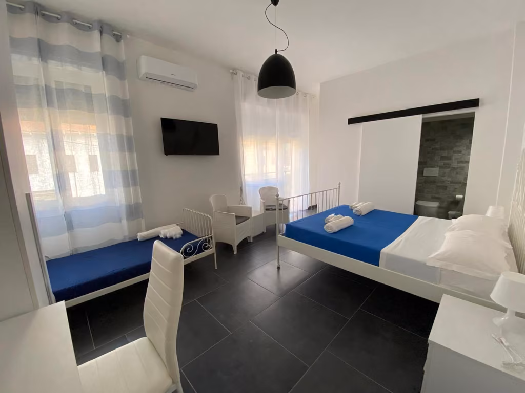 Camera da letto con letto, scrivania e TV